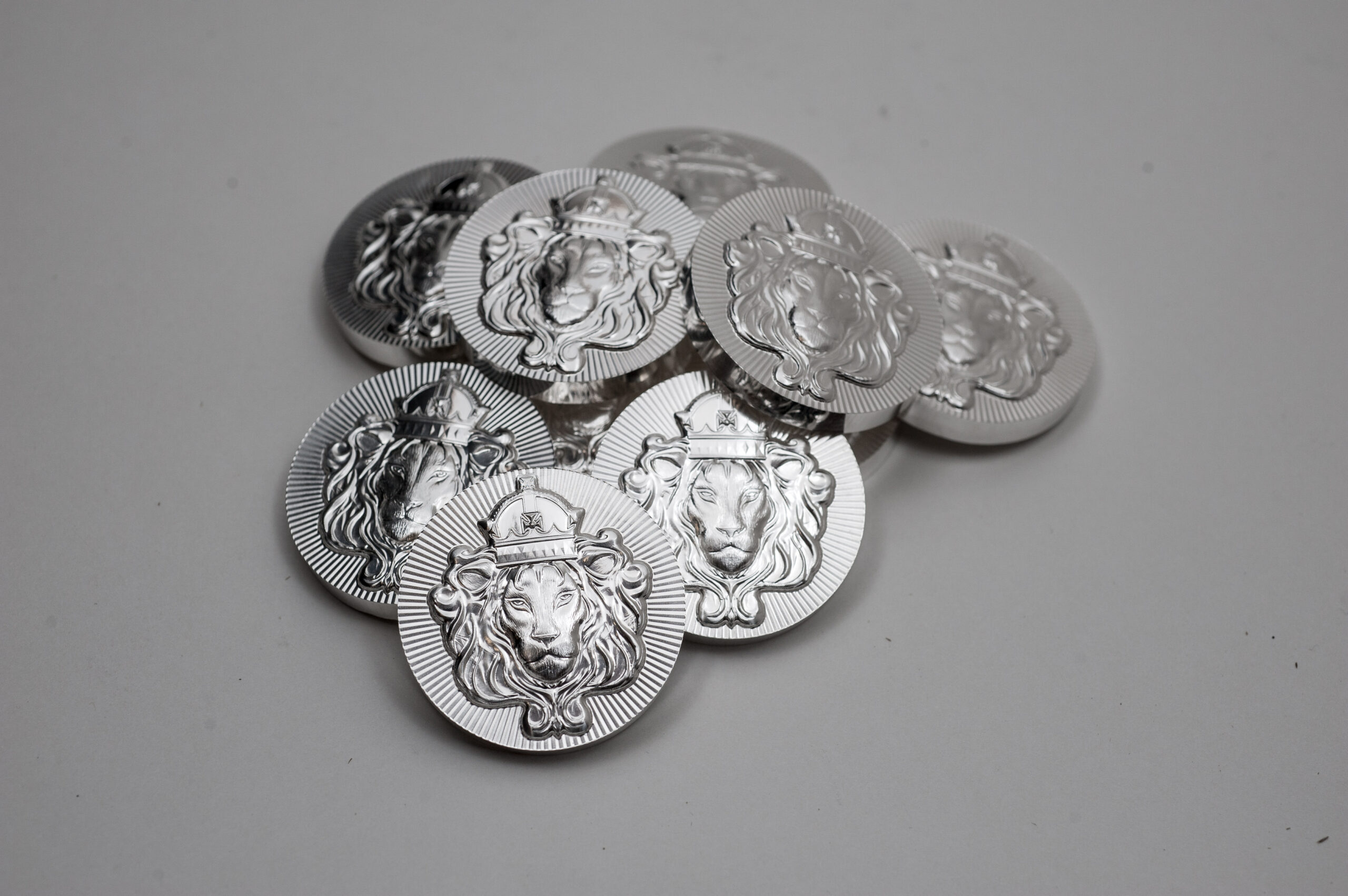 A group of silver coins with faces on them.